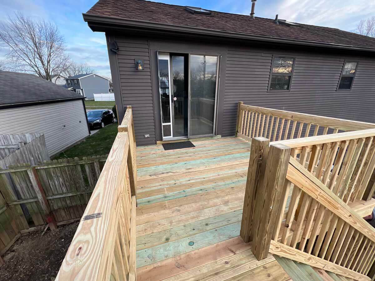 Wood deck with wood railings and a staircase installed off a second story room in Ohio